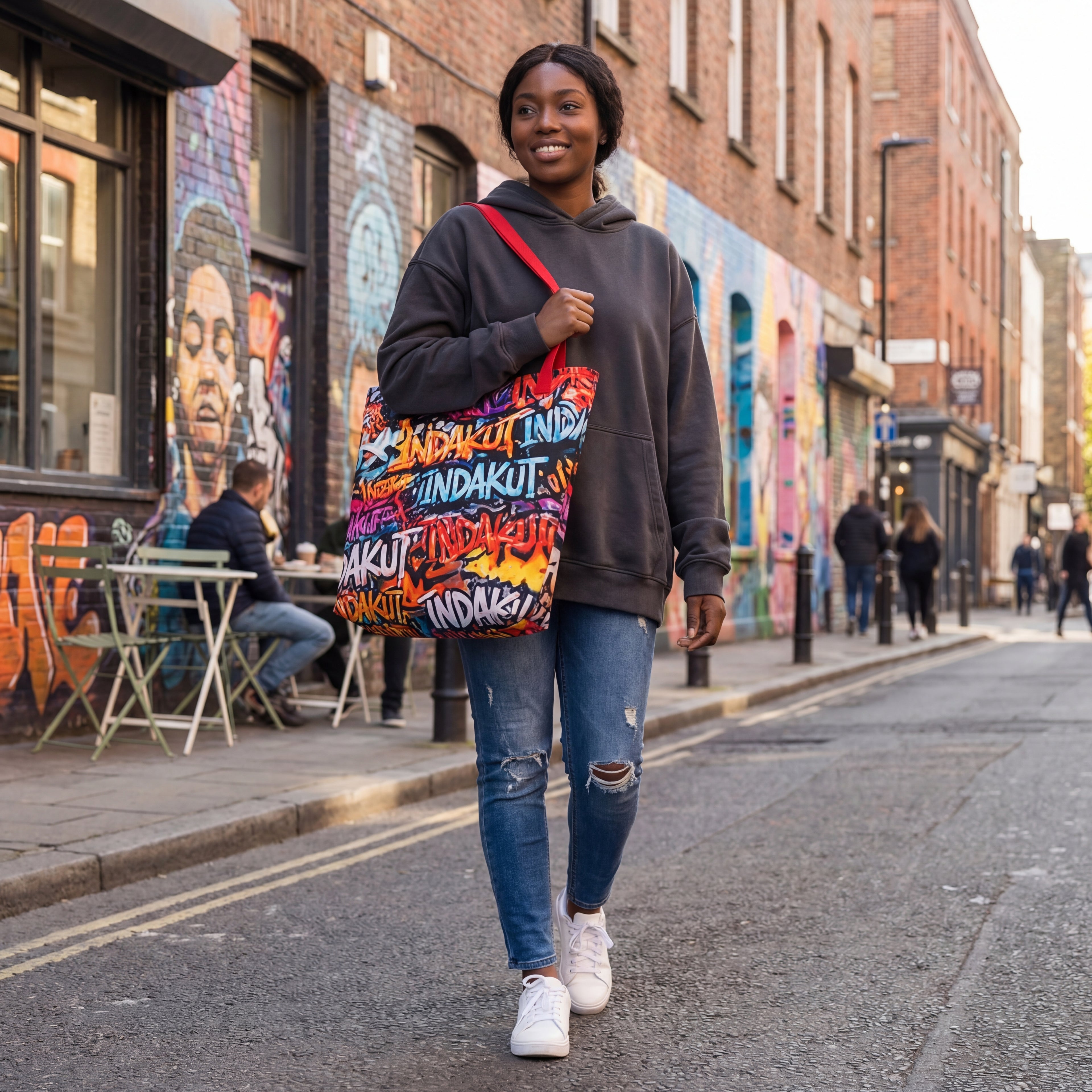 woman walking in city wearing large graffiti print tote bag with casual streetwear outfit